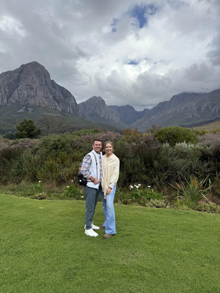 Couple visiting South Africa's Cape Winelands surrounded by mountain views.