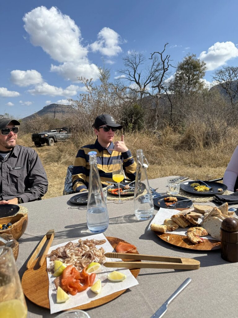 Family enjoying an outdoor bush breakfast during a South Africa safari.