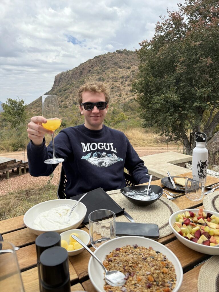 Guest enjoying breakfast and a mimosa during a luxury South Africa safari.