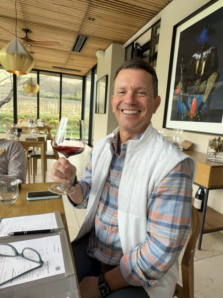 Guest enjoying a red wine tasting at a luxury winery in South Africa's Cape Winelands.